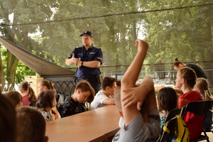 Policjanci prowadzą spotkanie z młodzieżą podczas warsztatów &quot;Wakacje w Pałacu&quot;