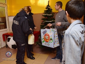 Policjanci wręczają prezenty wychowankom domów dziecka