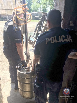 Policjanci podczas zabezpieczenia aparatury do wyrobu alkoholu etylowego